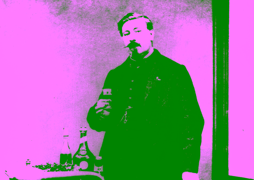 Photographie historique d’Alexandre Le Grand tenant un verre de Bénédictine dans son laboratoire.